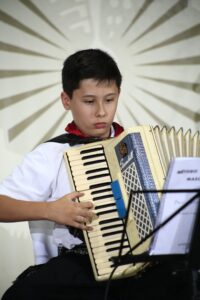 Aula de acordeon - aluno praticando com partitura